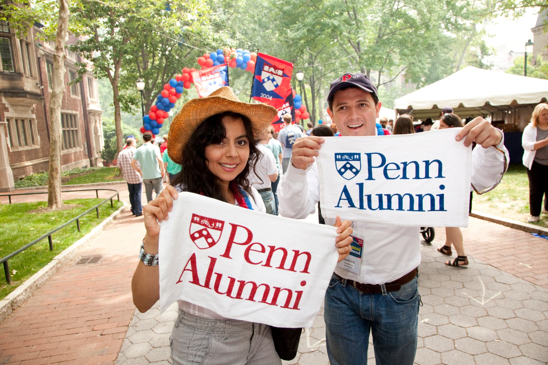 Penn alumni holding Penn Alumni towels at a campus event